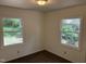 Bedroom featuring two windows, neutral walls, and dark flooring at 317 Gary St, Durham, NC 27703