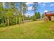 Spacious backyard featuring a well-maintained lawn, mature trees, and a wooden fence for added privacy at 32 Lattimore Rd, Cameron, NC 28326