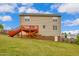 The backyard features a red wood deck, vinyl siding, and a walk-out basement entrance, complemented by a well-manicured lawn at 32 Lattimore Rd, Cameron, NC 28326