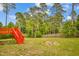 Large backyard showcasing a red wooden deck, providing a great space for outdoor entertaining and relaxation at 32 Lattimore Rd, Cameron, NC 28326