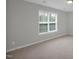 Bright bedroom featuring neutral carpet, window, and light fixture at 32 Lattimore Rd, Cameron, NC 28326