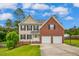 Charming two-story home featuring a brick and siding exterior, two-car garage, and well-manicured lawn at 32 Lattimore Rd, Cameron, NC 28326