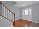 Bright foyer featuring wood floors, glass-paneled front door, and staircase with wooden banister at 32 Lattimore Rd, Cameron, NC 28326
