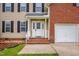 Inviting front porch with white columns, brick stairs, and a decorative glass front door at 32 Lattimore Rd, Cameron, NC 28326