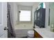Bathroom with a bathtub, toilet, and vanity with decorative hanging planter in front of a window at 3848 Griffis Glen Dr, Raleigh, NC 27610