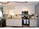Well-lit kitchen with white cabinets, granite counters, stainless steel appliances, and hardwood flooring at 3848 Griffis Glen Dr, Raleigh, NC 27610