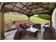 Covered patio with wood frame includes dark wicker patio furniture and flower bed at 3848 Griffis Glen Dr, Raleigh, NC 27610