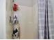 Standard shower space includes grey and white striped curtain and shelving for storing toiletries at 3848 Griffis Glen Dr, Raleigh, NC 27610