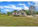 Wide backyard view of the house featuring a deck and detached garage at 397 Meadow Rd, Kenly, NC 27542