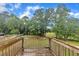 View from wood deck overlooking the backyard and trees on a sunny day at 397 Meadow Rd, Kenly, NC 27542