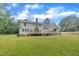 Spacious backyard view of the house featuring a deck and lush lawn at 397 Meadow Rd, Kenly, NC 27542
