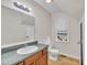 Bright bathroom featuring a vanity with a green countertop and a toilet next to a window at 397 Meadow Rd, Kenly, NC 27542