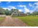 Well-maintained home featuring ample yard space, a gravel driveway, and lush trees at 397 Meadow Rd, Kenly, NC 27542