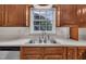 Kitchen featuring wooden cabinets and sink with a garden window view at 397 Meadow Rd, Kenly, NC 27542