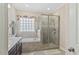 Elegant Primary bathroom with a glass-enclosed shower, soaking tub, and a dark vanity with great lighting at 422 River Ridge Ln, Timberlake, NC 27583