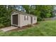 Well maintained backyard shed with garage door, side door, and fresh landscaping at 422 River Ridge Ln, Timberlake, NC 27583