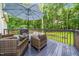 Back deck includes outdoor seating, an umbrella, and grill overlooking the lush backyard at 50 Peggy Ct, Raleigh, NC 27603