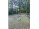 Backyard featuring a fire pit surrounded by a grassy yard and view of the woods at 50 Peggy Ct, Raleigh, NC 27603