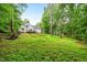 House with a deck from a large backyard with lots of green grass and tree coverage at 50 Peggy Ct, Raleigh, NC 27603