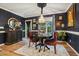 Charming dining room featuring dark blue walls, wood floors, and a chandelier at 50 Peggy Ct, Raleigh, NC 27603