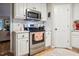 Bright kitchen with white cabinets, stainless steel appliances, and modern finishes at 50 Peggy Ct, Raleigh, NC 27603