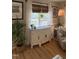 Close up of sideboard with decor, windows and hardwood floors in a neutrally decorated living room at 50 Peggy Ct, Raleigh, NC 27603