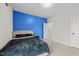 Bright bedroom features a blue accent wall, plush carpeting, and neutral colored furnishings at 5104 Windmere Chase Dr, Raleigh, NC 27616
