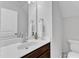 Clean bathroom with a white sink, wood vanity, and modern mirror at 5412 Robbins Dr, Raleigh, NC 27610