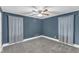Cozy bedroom featuring blue paint, carpet, ceiling fan, and breezy curtains at 5412 Robbins Dr, Raleigh, NC 27610