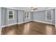 Spacious bedroom featuring hardwood floors, ceiling fan, large windows, and trim at 5412 Robbins Dr, Raleigh, NC 27610