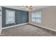 Bedroom features blue accent wall, two windows, gray carpet, and a ceiling fan at 5412 Robbins Dr, Raleigh, NC 27610