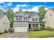 Beautiful two-story home with gray siding, black shutters, and a well-manicured lawn at 5412 Robbins Dr, Raleigh, NC 27610