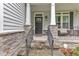 Inviting front entrance with stone accents, iron railing, and a black front door at 5412 Robbins Dr, Raleigh, NC 27610