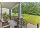 Cozy front porch with stone columns, seating, and views of lush greenery at 5412 Robbins Dr, Raleigh, NC 27610