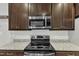 Well-equipped kitchen features granite countertops, subway tile backsplash, and stainless steel appliances at 5412 Robbins Dr, Raleigh, NC 27610