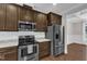 Modern kitchen with stainless steel appliances, granite countertops, dark cabinets, and subway tile backsplash at 5412 Robbins Dr, Raleigh, NC 27610