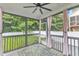 Screened porch with ceiling fan, curtains, and a decorative rug at 5412 Robbins Dr, Raleigh, NC 27610