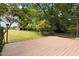 An exterior view of the home's backyard featuring a wood deck and large grassy space at 59 Troy Dr, Fuquay Varina, NC 27526
