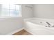 Bathroom showcasing a large soaking tub by a bright window, perfect for relaxing in a soothing environment at 59 Troy Dr, Fuquay Varina, NC 27526