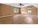 Bedroom featuring wood floors, two bright windows, and ceiling fan, offering style and convenience in a compact space at 59 Troy Dr, Fuquay Varina, NC 27526