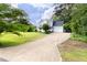 Traditional home with a long driveway and attached garage, surrounded by mature trees and landscaping at 59 Troy Dr, Fuquay Varina, NC 27526