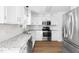 Modern kitchen featuring granite countertops, white cabinets, stainless appliances, and tile backsplash at 59 Troy Dr, Fuquay Varina, NC 27526
