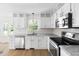 Bright kitchen featuring white cabinetry, granite countertops, stainless steel appliances, and wood flooring at 59 Troy Dr, Fuquay Varina, NC 27526