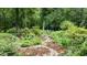 Lush backyard garden path with stone pathway, leads to relaxing outdoor seating area at 5916 Two Pines Trl, Wake Forest, NC 27587
