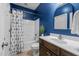 Bathroom featuring blue walls, a shower-tub combo with curtain, and a decorative plant at 5916 Two Pines Trl, Wake Forest, NC 27587