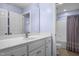 Bright bathroom featuring a white vanity, large mirror, and a glimpse into the shower area at 5916 Two Pines Trl, Wake Forest, NC 27587