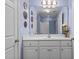 Clean bathroom featuring white cabinetry, a large mirror, and decorative lighting, creating a bright and functional space at 5916 Two Pines Trl, Wake Forest, NC 27587