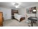 Cozy bedroom with a ceiling fan, featuring a comfortable bed, a modern desk, and a closet for ample storage at 5916 Two Pines Trl, Wake Forest, NC 27587