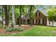 Charming brick home with inviting front porch and manicured lawn, framed by mature trees and colorful flowers at 5916 Two Pines Trl, Wake Forest, NC 27587