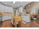 Well-lit kitchen with white cabinets, wooden island, hardwood floors and open floor plan to the living room at 5916 Two Pines Trl, Wake Forest, NC 27587